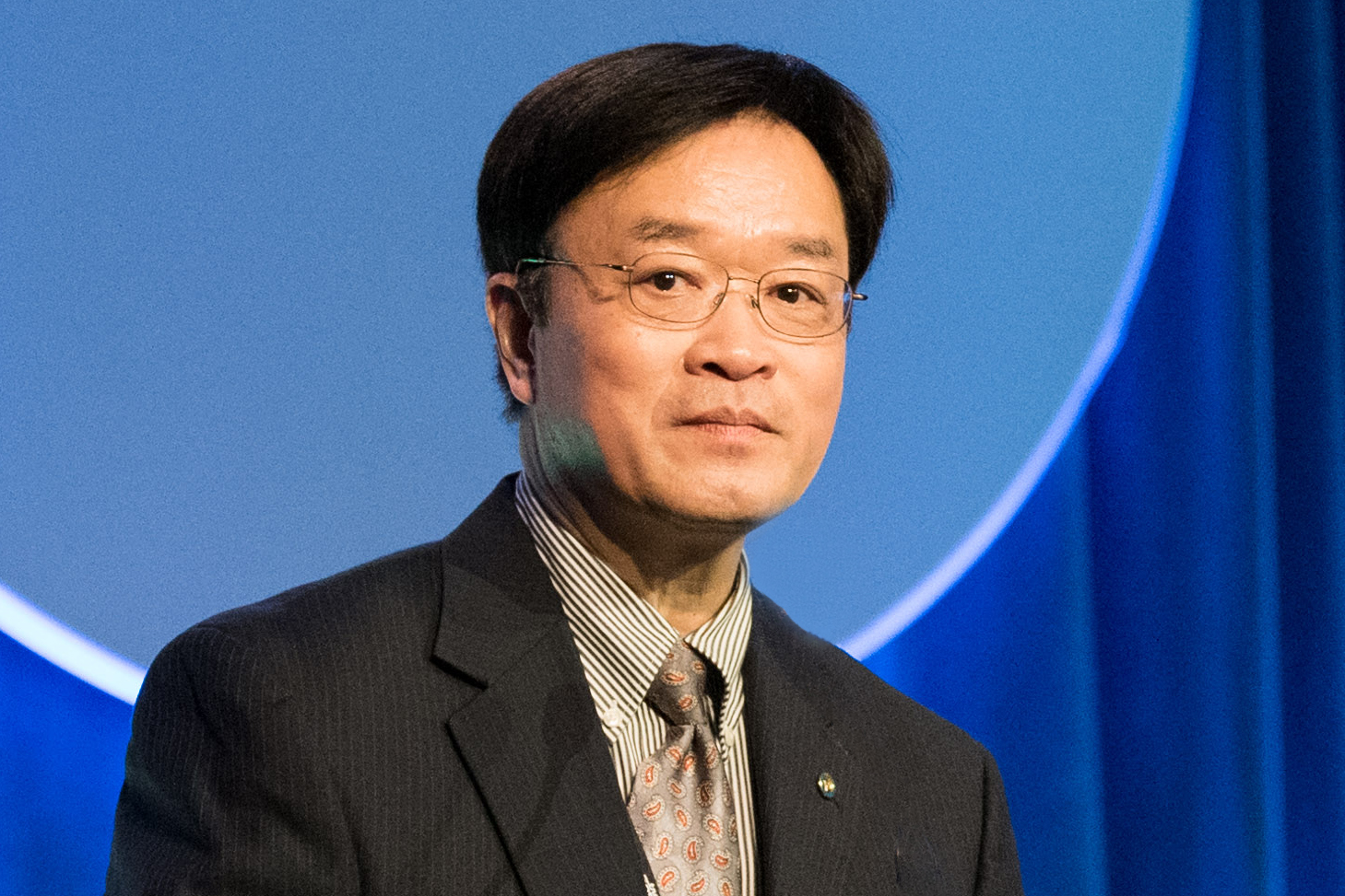 Headshot photo of Bin Zhao on blue background